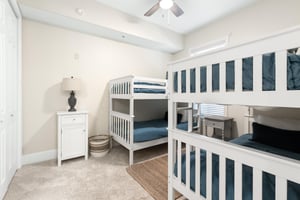 Bright bedroom with two white bunk beds, perfect for the kids to enjoy their own cozy retreat during your family getaway.