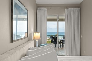 Wake up to peaceful ocean views from your bed. Soft curtains frame sliding doors leading to your private balcony, where morning coffee awaits overlooking endless blue water.