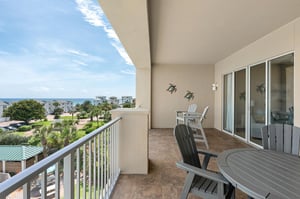 Private covered balcony features coastal views, outdoor dining, and relaxed seating—perfect for morning coffee or sunset moments by the sea.