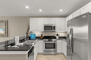 Your fully equipped kitchen features stainless steel appliances, sleek white cabinetry, and granite countertops—perfect for preparing favorite meals during your stay.