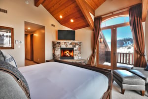 Third bedroom suite with private patio overlooking Bald Mountain, gas fireplace  with stone surround, and flat screen TV.