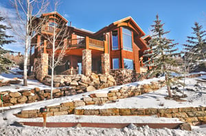 Thistle Home exterior with large flagstone and wood beams, private decks, striking windows and stone lined driveway.