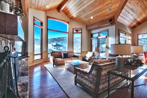 Expansive front room with stunning floor to ceiling windows, wood beams and ceiling and hardwood floors throughout.