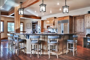 Two kitchen islandsone wrap around and one center island, both have sinks, medium wood cabinets, and granite countertops.