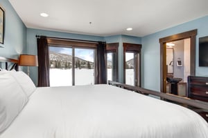 The main suite with a king size bed and large sliding glass door look over the lake and mountains.