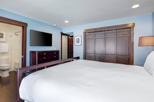 The main suite with a king size bed, comfortable furnishings, and flat screen TV.
