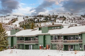 The exterior of the property with a snowy mountain behind it.