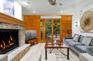 Relax in your stylish living room with a gas burning fireplace and mountain views through glass doors.