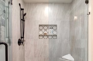 Step into your private spalike shower, with grey travertine tiles and modern fixtures.