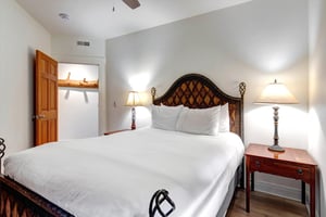 The third bedroom offers a plush queen bed, elegant furnishings, and soft bedside lighting.