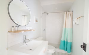 The bath features a standing shower with subway tile and caddy.