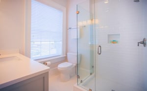 The upstairs bathroom has a glass enclosed shower and rainfall shower head.