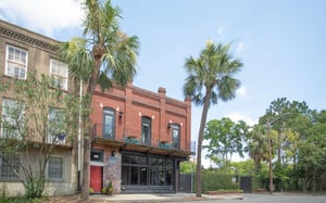 Look for the home between two palms.