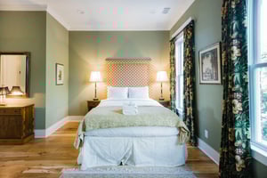 A plush queensize bed fitted with white, crisp linens.