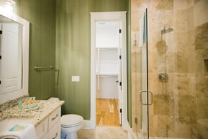 The en suite bathroom features a tiled walkin shower, and spacious vanity.