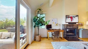 Cozy living room offers plush seating, 50” smart TV, gas fireplace, work desk, access to a private deck
