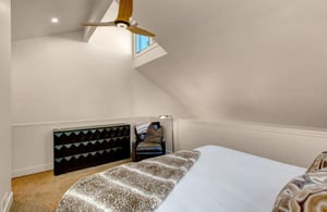 Elegant upstairs loft bedroom offering a king bed, private ensuite bathroom, and a cozy sleeping nook with a doublesize futon