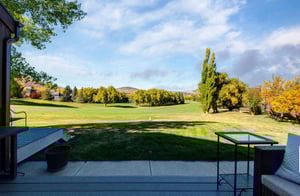 Expansive private deck with BBQ grill and stylish outdoor furnishings, offering breathtaking panoramic views of the golf course and resort area.