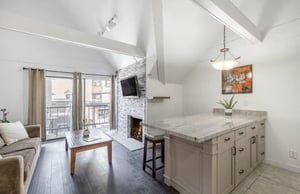 Bright, airy living spaces with a cozy fireplace and private balcony await at Lodge at Mountain Village 303 — your skiinskiout home base at Park City Resort.