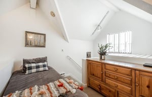 Room for everyone in the charming upstairs guest bedroom at Lodge at Mountain Village 303, featuring a queen bed, twin bed, and ceiling fan — your skiinskiout Park City Resort getaway.
