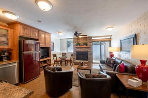 Room to relax at Park Avenue 211, where a stone fireplace, comfortable seating, and an open layout make every evening feel like a true mountain escape.