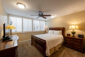 Bright and comfortable, the bedroom at Park Avenue 211 features a queen bed, ceiling fan, and plenty of natural light for a restful nights sleep.