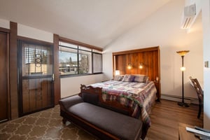 Warm wood accents, a cozy quilt, and natural light — the bedrooms at Park Avenue 216 are a true retreat within your Park City vacation rental.