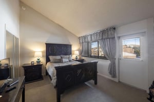 Drift off to sleep in the beautifully appointed primary bedroom at Park Avenue 251, where vaulted ceilings, warm lighting, and mountain views create the perfect end to every Park City lodging adventur