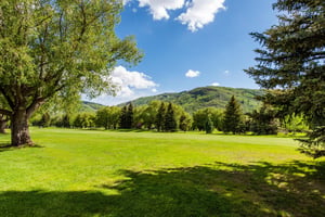 The view from the back patio at Park Avenue 267 stretches across lush golf course fairways to dramatic mountain peaks — an unbeatable backdrop that defines the best of Park City condo rentals on the g