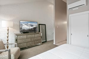 Every comfort is accounted for in the elegant primary bedroom at Park Avenue 296. From the glamorous mirrored dresser to the flat screen TV, the thoughtful touches throughout this Park City vacation r