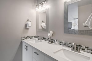 The stunning primary bathroom at Park Avenue 296 features a double vanity, quartz countertops, and elegant mosaic tile accents. Spalike finishes that elevate this Park City vacation rental to a truly