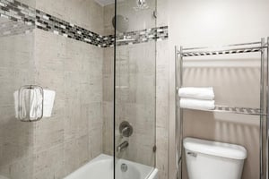 The beautifully tiled shower and bath at Park Avenue 296 features elegant mosaic accents and modern fixtures, offering a spalike experience after a day on the slopes. Upscale details like these set t