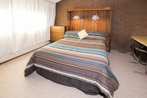Rest up for another day of adventure in the cozy queen bedroom at Park Avenue 314. Warm wood accents, exposed brick, and colorful bedding give this room a charming, mountain lodge feel that guests lov