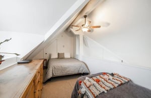 A cozy upstairs guest bedroom with a queen, twin, and ceiling fan makes Lodge at Mountain Village 303 perfect for families and friends — skiinskiout at Park City Resort.