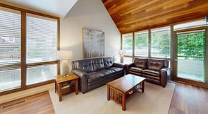 Kick back and relax in the stylish living room at Pay Day 189 Rich leather sofas, soaring woodpaneled ceilings, and plenty of natural light make this Park City vacation rental the perfect place to u