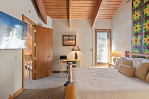 Natural light and warm wood accents set the tone in this relaxing bedroom at 1296 Pinnacle, one of Park Citys most soughtafter lodging options for a restful and rejuvenating mountain getaway.