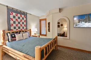 Rest and recharge in this warmly decorated queen bedroom at 1296 Pinnacle — a standout Park City lodging destination where rustic details and thoughtful design make every guest feel right at home.