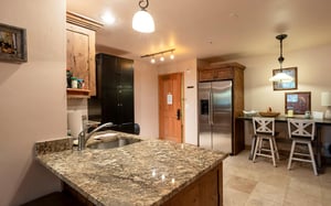 The kitchen at Jupiter Inn 18 offers generous granite counter space, ample cabinetry, and a fullsize refrigerator — everything you need to feel right at home during your Park City vacation rental sta