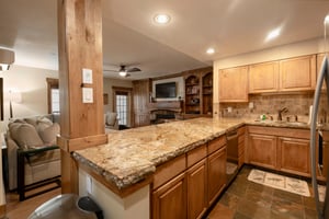 The open kitchen and living area at Resort Plaza 5002 makes entertaining effortless — this Park City lodging features beautiful granite counters, rich wood cabinetry, and a seamless flow perfect for g