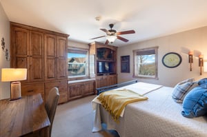 Resort Plaza 5002 delivers on every detail — this wellappointed bedroom in our Park City vacation rental offers beautiful wood cabinetry, a flatscreen TV, and stunning natural light pouring in from