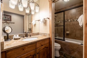 Every detail counts at Resort Plaza 5002 — this Park City vacation rental features a beautifully finished bathroom with warm wood vanity, granite countertops, and a sleek glassenclosed shower for a s