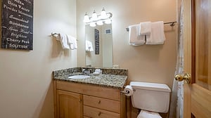 Resort Plaza 5013 features a clean and tastefully finished bathroom with granite countertops and warm wood vanity — a lovely touch in this soughtafter Park City vacation rental.