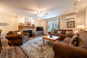 Cozy up by the fireplace in the spacious living room at Resort Plaza 5022 — a warm and inviting Park City vacation rental perfect for relaxing after a day on the slopes.