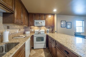 Cook up your favorite meals in the fully equipped kitchen at Resort Plaza 5009 — a Park City condo rental featuring granite countertops, rich wood cabinetry, and all the appliances you need for a comf