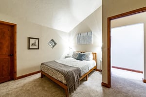 Tuck in under the vaulted ceilings of this warm and welcoming bedroom at Park Avenue 245 — a peaceful haven that makes your stay in Park City feel like a true mountain escape.