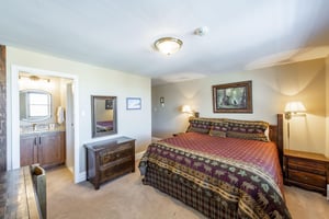 This spacious primary bedroom features warm mountaininspired décor and generous floor space, offering a peaceful and comfortable retreat after a day of adventure. A restful nights sleep awaits at th