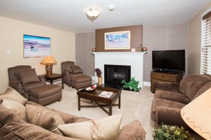 Gather around the cozy fireplace in this comfortable and welcoming living room, featuring plush seating and warm, relaxed décor perfect for unwinding after a day on the mountain. A true home away from