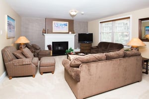Bright and spacious, this comfortable living room features a classic white fireplace, generous seating, and plenty of natural light for a warm and welcoming atmosphere during your Park City vacation r