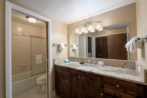 Warm wood finishes, granite countertops, and bright vanity lighting make this guest bathroom a polished and functional space. Consistent quality throughout Resort Plaza 5040 makes it a top choice for