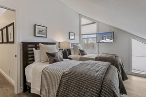 Relax in your cozy retreat with two plush beds and natural light streaming through large windows. The crisp linens and peaceful decor create a restful escape.
